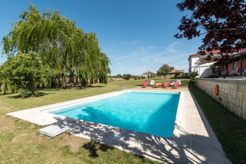 Piscina Casa das Jardas com espreguiçadeiras, salgueiros-chorões e paisagem rural em Ladoeiro, Portugal
