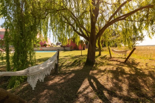 Propriedade rústtica em Casa das Jardas com redes sob salgueiros-chorão, cerca branca e prédios vermelhos na zona rural de Portugal