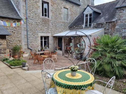 Charmante cour en pierre aux Forges Du Lou avec tables de repas et jardin à Jugon-les-Lacs