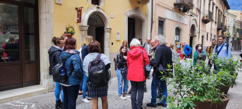 Reisegruppe versammelt sich vor dem Hotel Stella CasaBono auf dem historischen Platz von Sulmona, mittelalterliche Architektur sichtbar