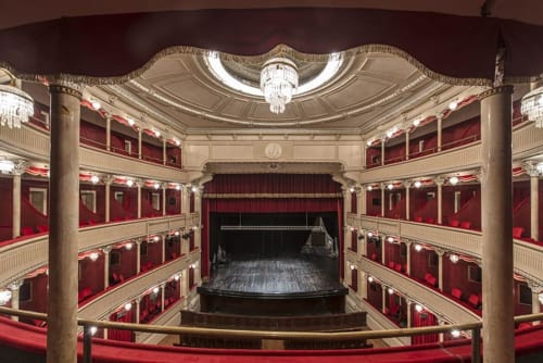 Historic theater interior at Stella CasaBono hotel in Sulmona with red velvet balconies and ornate ceiling