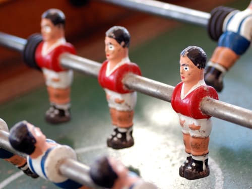 Jogo de pebolim na Casa das Jardas, casa rural em Ladoeiro, Portugal - jogadores em miniatura vermelho e azul em hastes metálicas