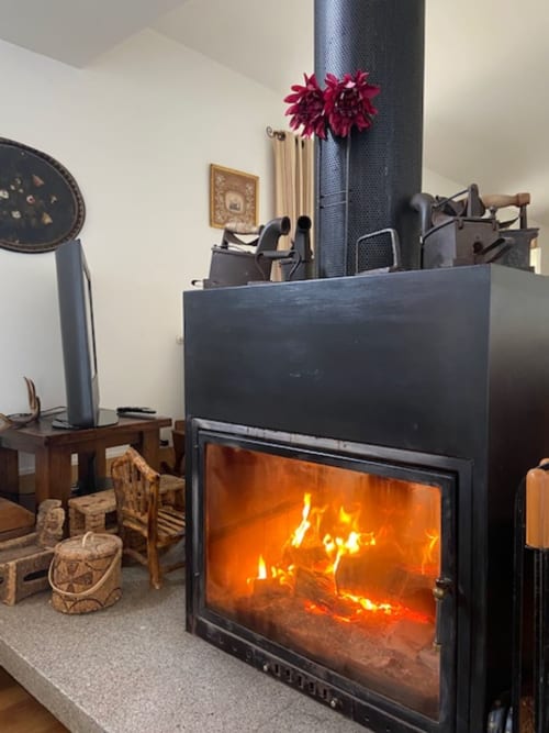 Acogedor hogar con fuego brillante en Casa das Jardas, rural B&B en Ladoeiro, Portugal, decorado con flores borgoña