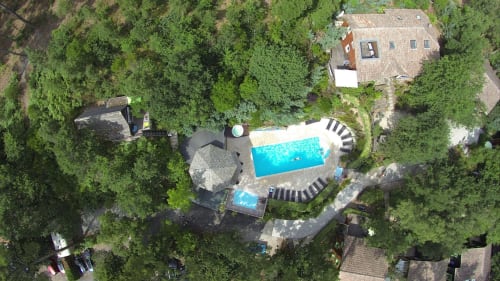 Vue du ciel de la piscine et ses transats, de la pataugeoire et de la villa 