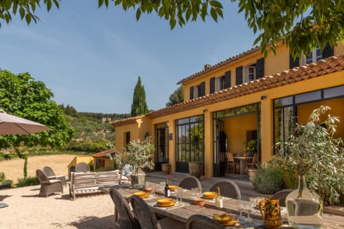 Terrasse du gîte Saint Martin à Ollioules : coin repas extérieur, villa jaune et vue sur la campagne