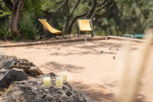 Beach games setup at Saint Martin B&B in Ollioules with bocce balls, loungers, and tree shade