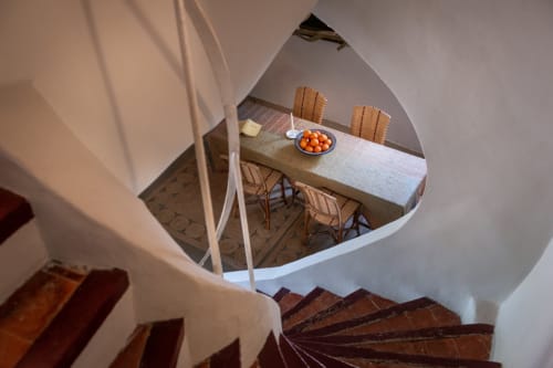 Spiral staircase view to dining area at Saint Martin B&B Ollioules with table, chairs, and oranges