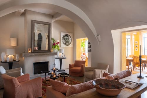 Salon élégant du gîte Saint Martin à Ollioules avec cheminée, fauteuils en terre cuite et plafonds voûtés