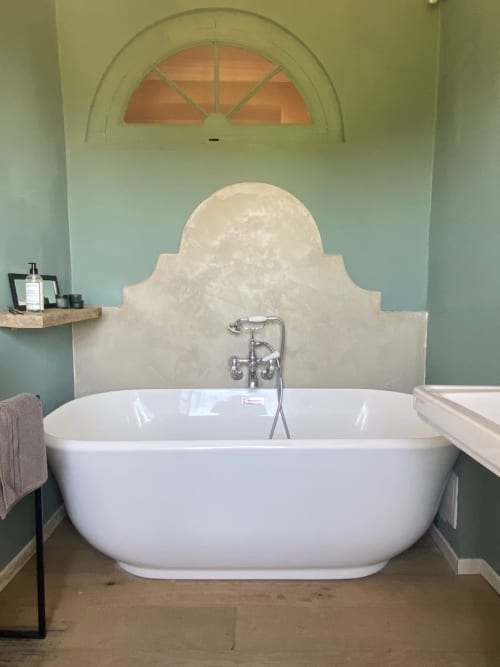 Luxurious soaker tub at Saint Martin B&B in Ollioules with arched window and cream tilework