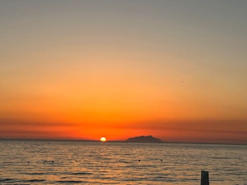 Spektakularny zachód słońca nad brzegiem Marsali z sylwetką wyspy, widok na plażę Villa Blanche Holidays