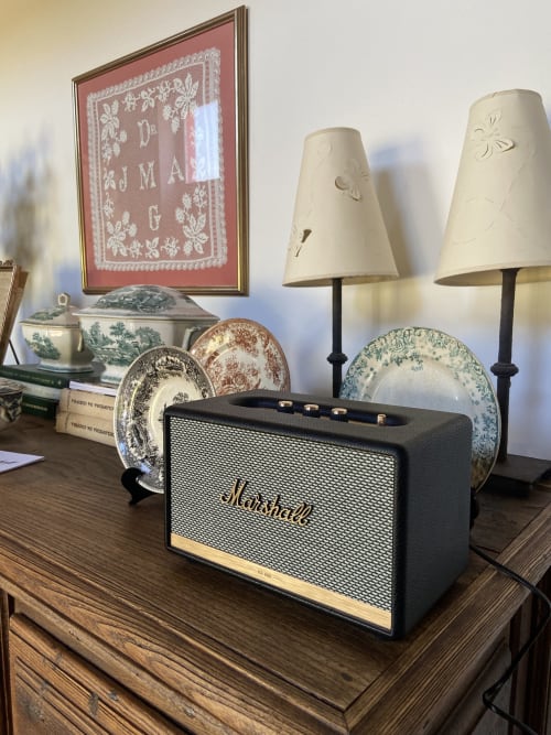 Altavoz Marshall con platos decorativos y lámparas sobre la cómoda en Casa das Jardas, hotel rural de Portugal