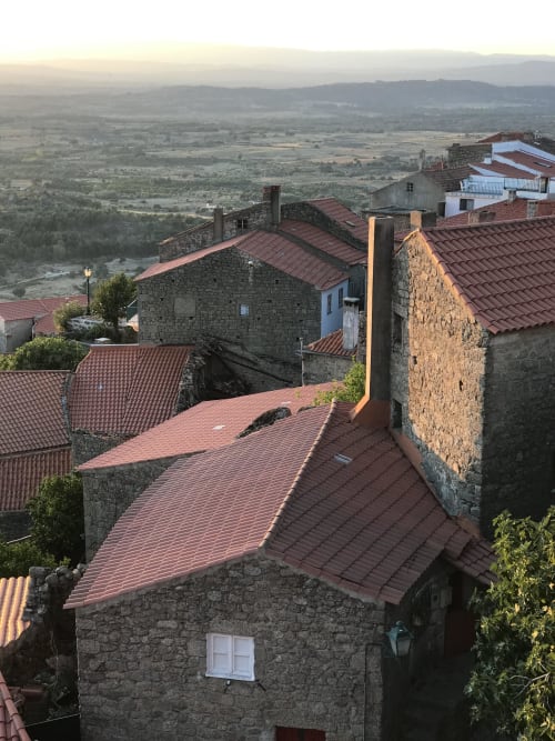 Stone houses with red tile roofs at Casa das Jardas overlooking Ladoeiro valley at sunset