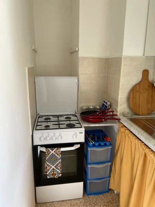 Cucina compatta nell'appartamento Palazzo Porta a Procida con fornello a gas, forno e ripostigli in uno spazio ridotto