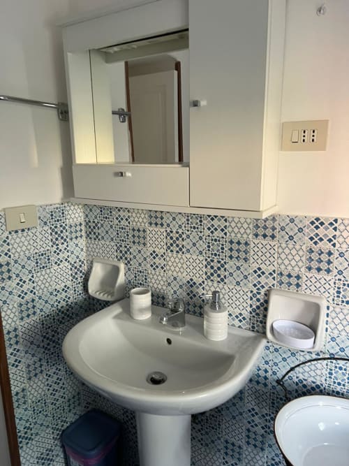 Lavabo moderno con piastrelle blu a motivi nell'appartamento Palazzo Porta a Procida