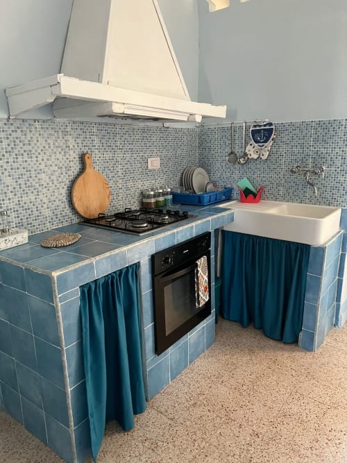 Cucina costiera a Palazzo Porta, Procida con rivestimento in piastrelle blu, fornello a gas, lavello bianco e arredamento nautico