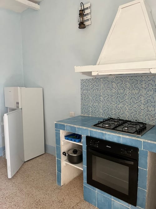 Cucina moderna con piano cottura a gas, forno e frigorifero nell'appartamento Palazzo Porta a Procida
