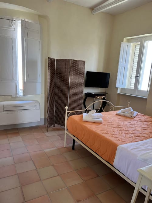 Luminosa camera a Palazzo Porta, Procida con letto, TV, climatizzatore e pavimenti in cotto