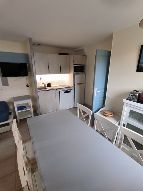 Cuisine et salle à manger modernes de Loc'Maria à Belle Île en Mer avec mobilier blanc et vue sur mer