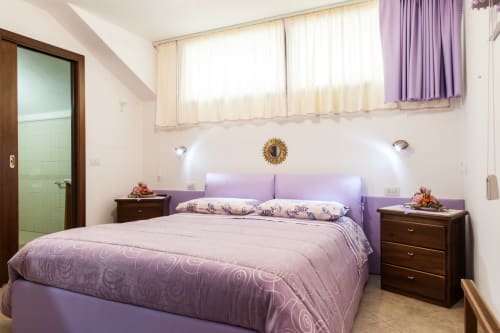 Bright bedroom with purple bedding and headboard at Affittacamere Al Mare in Torre Grande, Oristano, Italy