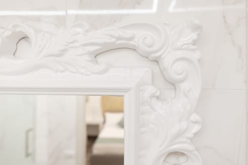 Detalhe de moldura decorativa branca ornamentada e marco de espelho no quarto Kalsa do B&B I Mori, Catânia