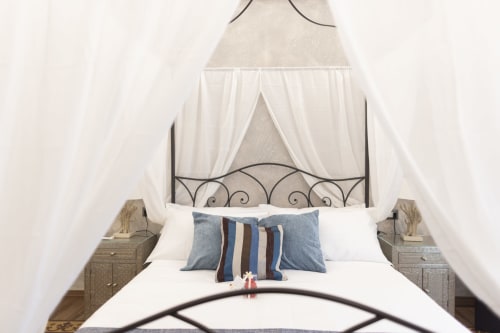 Letto elegante con baldacchino bianco e testata in ferro battuto nella camera Gli Amanti del B&B I MORI Catania