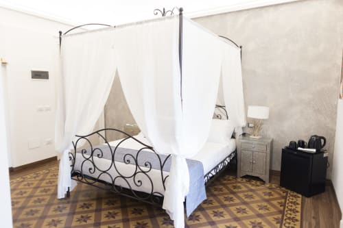 Elegante letto a baldacchino con drappeggi bianchi nella camera Gli Amanti del B&B I MORI, Catania