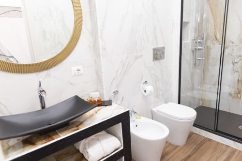 Bagno moderno nella camera Gli Amanti del B&B I MORI Catania con lavabo nero, pareti in marmo e doccia walk-in
