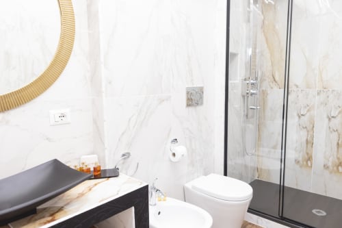 Bagno moderno del B&B I MORI a Catania con pareti in marmo, doccia in vetro, doppi servizi igienici e servizi