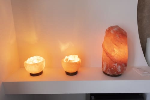 Tres lámparas de sal del Himalaya brillantes en estante blanco de la habitación Basileus del hotel B&B I Mori Catania