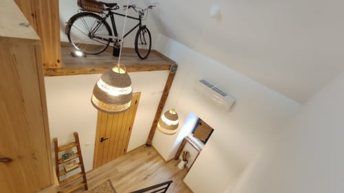 Quarto aconchegante em loft na pousada de Óbidos com guarda-bicicletas, luminárias de crochê, vigas de madeira e comodidades modernas