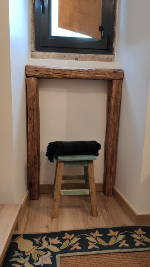 Porta de madeira rústica com banqueta verde e manta preta no quarto da pousada Kindnessmoon, Óbidos Portugal