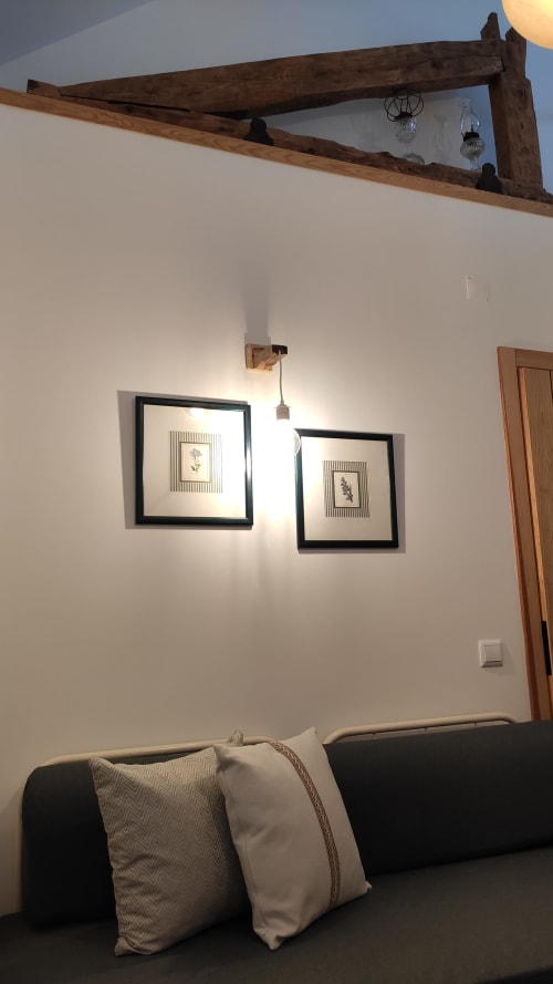 Quarto aconchegante na Kindnessmoon em Óbidos com arte botânica em moldura preta, vigas de madeira e sofá estofado