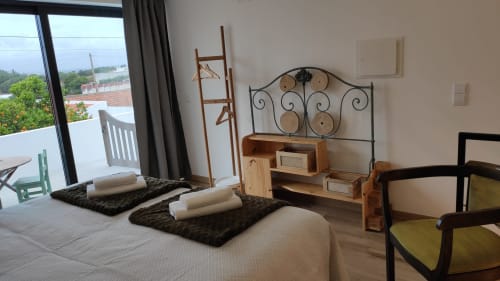 Quarto espaçoso em Kindnessmoon em Óbidos com vista da cidade, móveis de madeira, cama de ferro forjado preto e varanda