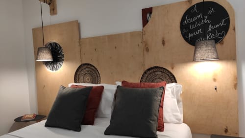 Quarto aconchegante na pousada Kindnessmoon, Óbidos, com cabeceira de madeira, luminárias pendentes e almofadas decorativas