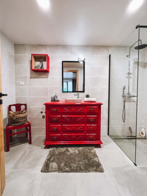 Banheiro moderno na Kindnessmoon em Óbidos com penteadeira vermelha, espelho preto, duche walk-in e azulejos em tons neutros