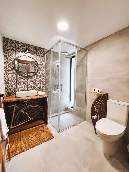 Banheiro moderno na Kindnessmoon B&B em Óbidos com azulejos estampados, box de chuveiro e vaidade em madeira
