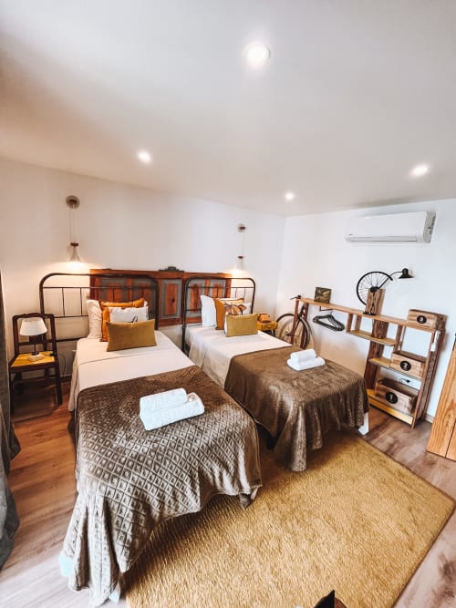Quarto moderno com duas camas, decoração em madeira e ar condicionado na Kindnessmoon B&B em Óbidos, Portugal