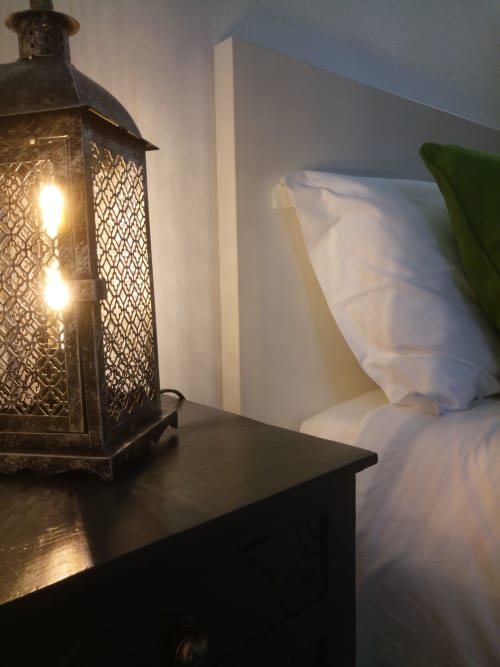 Lanterna preta ornamentada com velas acesas sobre a mesa-lateral da villa Kindnessmoon em Óbidos, Portugal