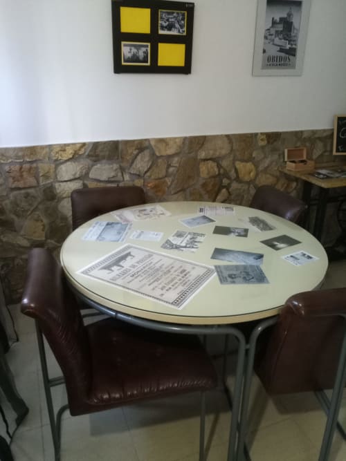 Mesa redonda com documentos históricos e fotografias na vila Kindnessmoon em Óbidos, Portugal