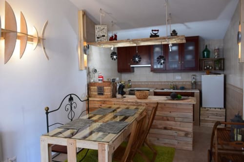 Rustic kitchen and dining area in Casa d'Amélia villa at Kindnessmoon in Óbidos, Portugal, with wooden furnishings and modern