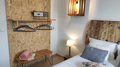 Cozy bedroom at Kindnessmoon in Obidos with cork wall, wooden bed, sitting area, and warm lighting