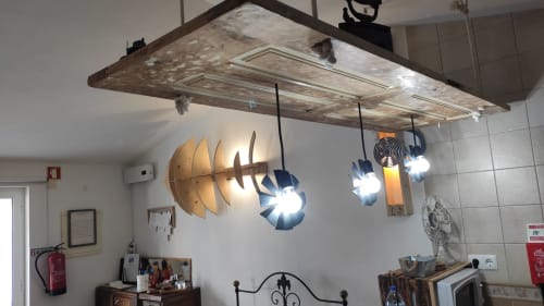 Rustic wooden ceiling fixture with brass disc sculpture and illuminated pendant lights in Casa d'Amélia villa, Óbidos