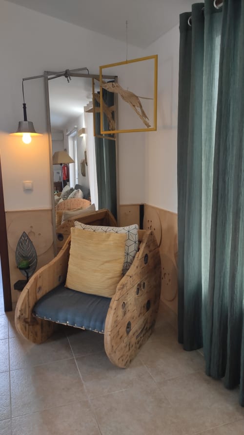 Wooden boat-shaped chair with cushions in villa sitting area at Kindnessmoon Obidos Portugal