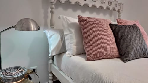 Quarto aconchegante na villa Kindnessmoon em Óbidos com cama branca, almofadas rosa e escuras, luminária vintage e vista da cidade