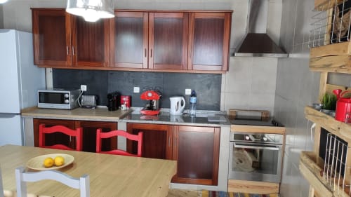 Cozinha moderna na vila Casa 40th Wood Music House em Óbidos com cadeiras vermelhas, mesa de jantar em madeira e aço inoxidável