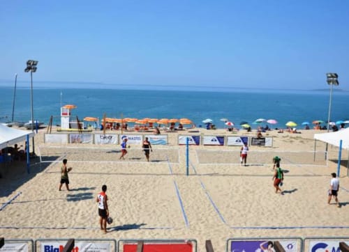 Torneo di pallavolo da spiaggia a Torre Grande Oristano con giocatori che competono su campi di sabbia a bordo mare