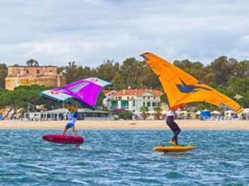 Kitesurfisti con aquiloni colorati sulla spiaggia Torre Grande vicino all'hotel Affittacamiere Al Mare, Oristano Italia