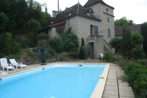 Piscine des Chambres d'hôtes Les Pratges avec le manoir en pierre à Figeac, France