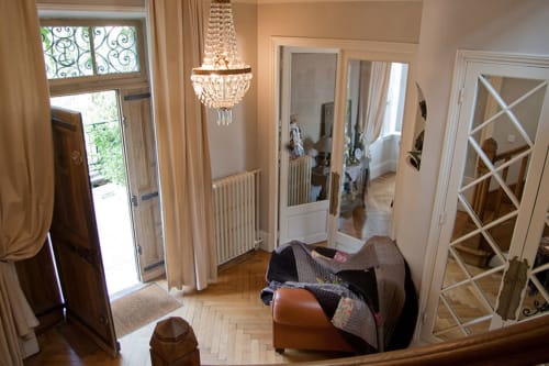 Élégant couloir des Chambres d'hôtes Les Pratges à Figeac avec lustre en cristal, miroirs et parquet