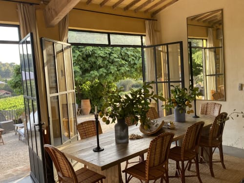 Salle à manger rustique de la chambres d'hôtes Saint Martin à Ollioules avec table en bois, chaises en osier et vue sur le jardin